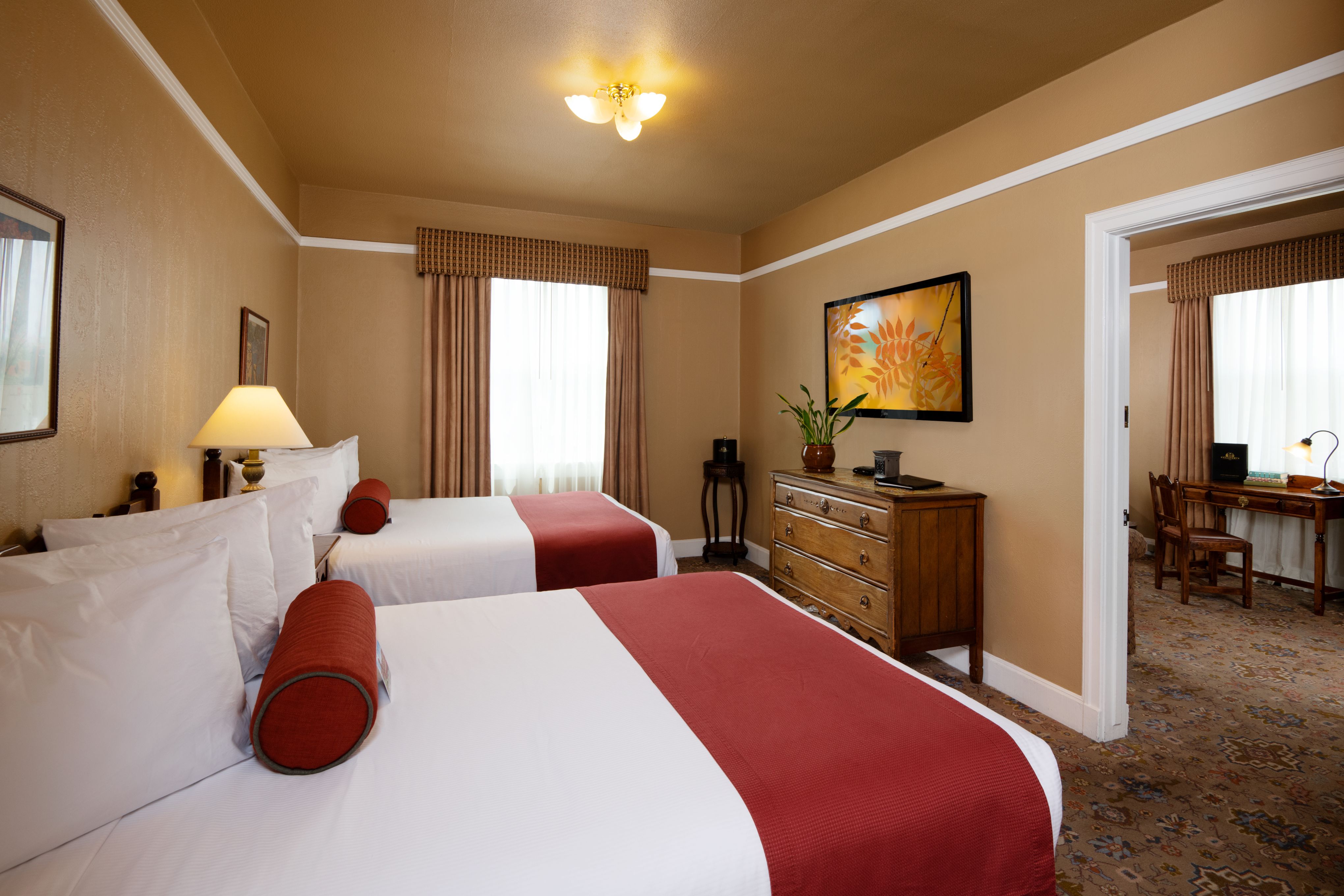 a room with two beds and a dresser