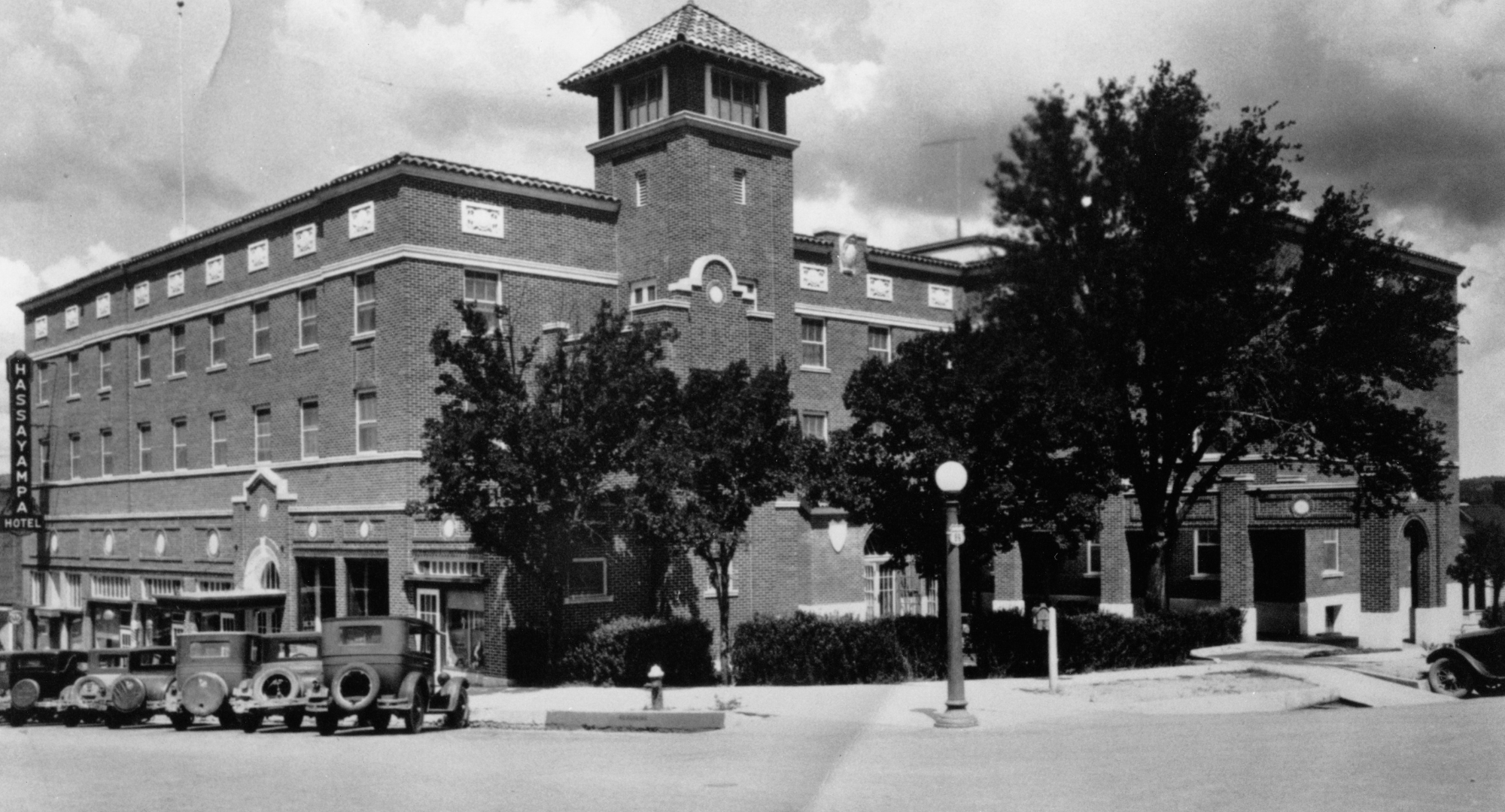 a building with a tower and a car parked in front of it