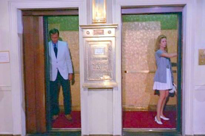a man and woman standing in elevator doors