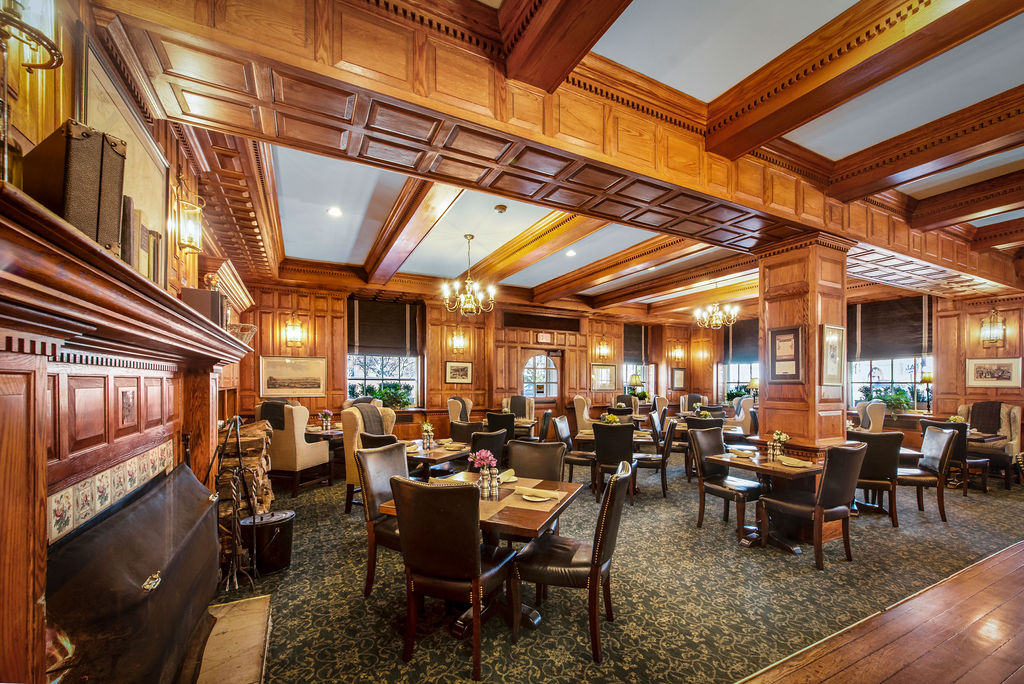 a room with wood paneling and tables and chairs