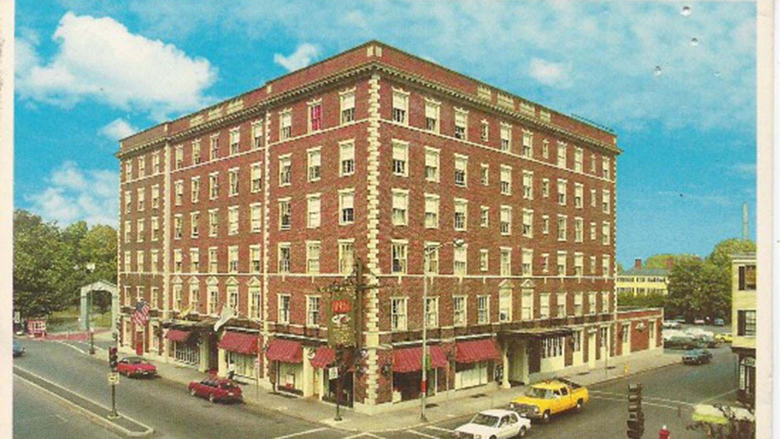a building with cars parked on the corner of the street