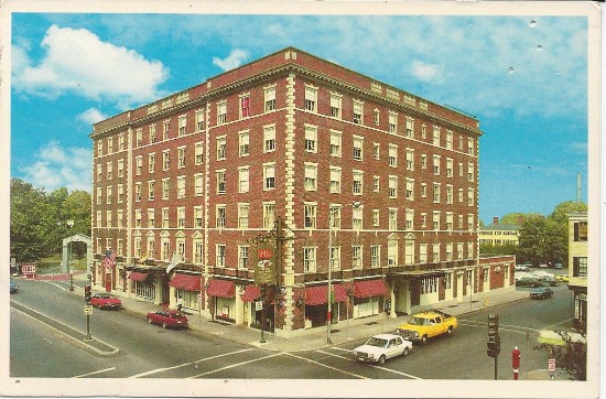 a large brick building with cars parked on the corner of a street