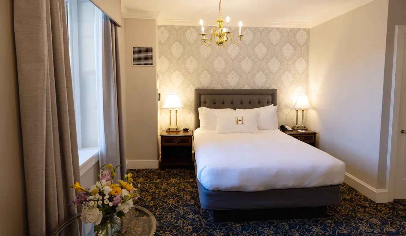 a bed with a chandelier and flowers in a room