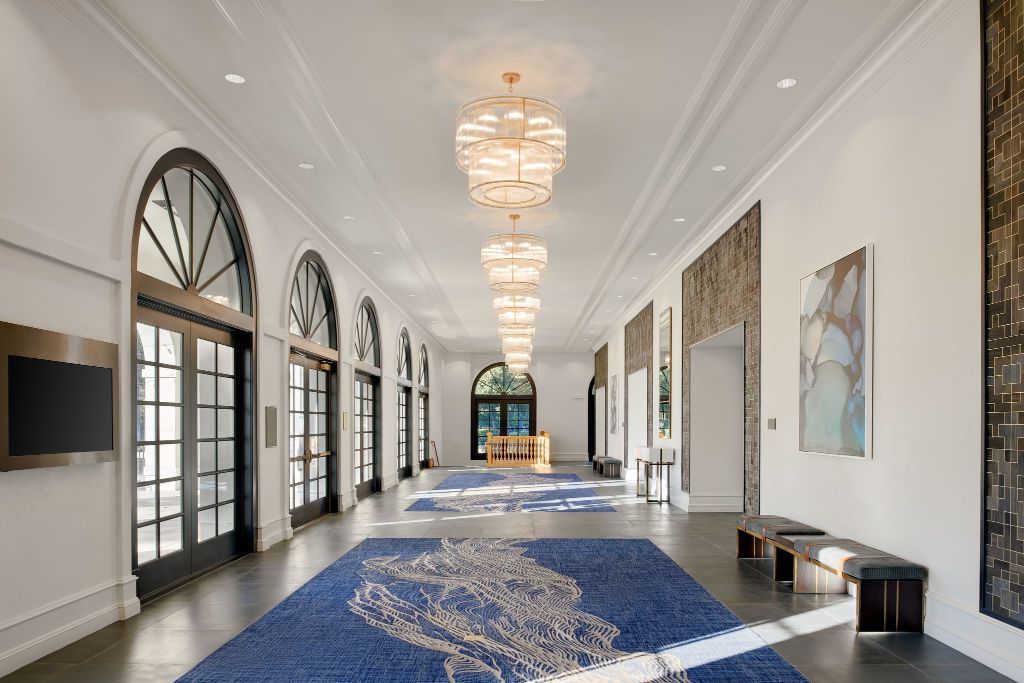 a hallway with a blue rug and art on the ceiling