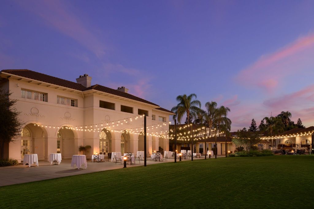 a building with a lawn and tables and chairs