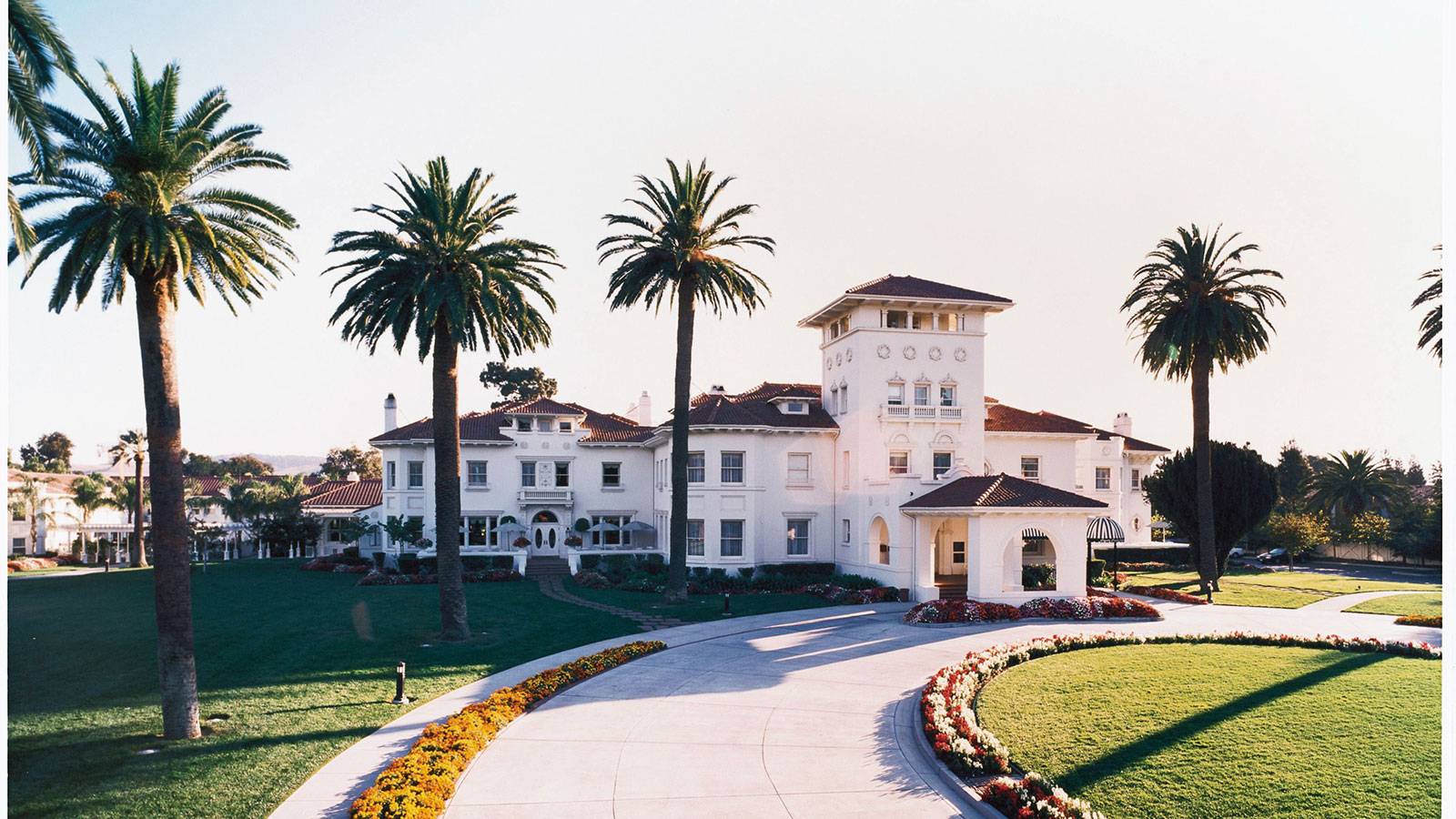 a large white building with palm trees