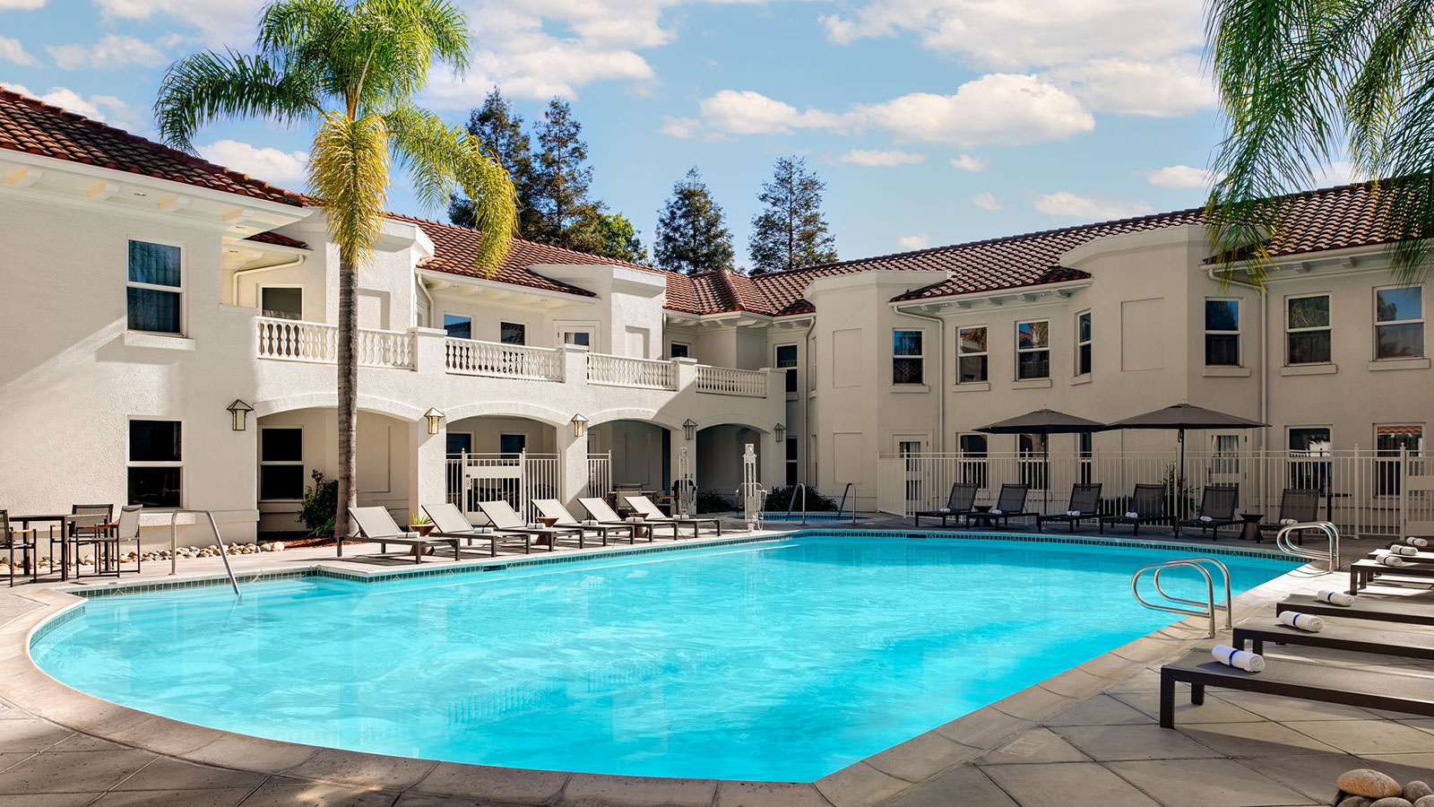 a pool with lounge chairs and a building