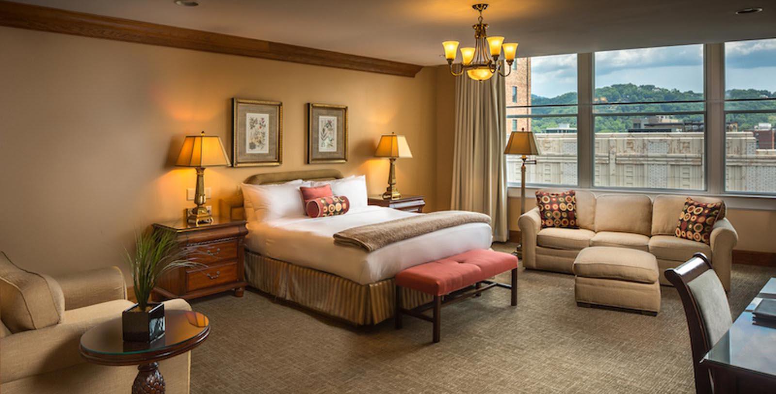 a room with a bed and chairs