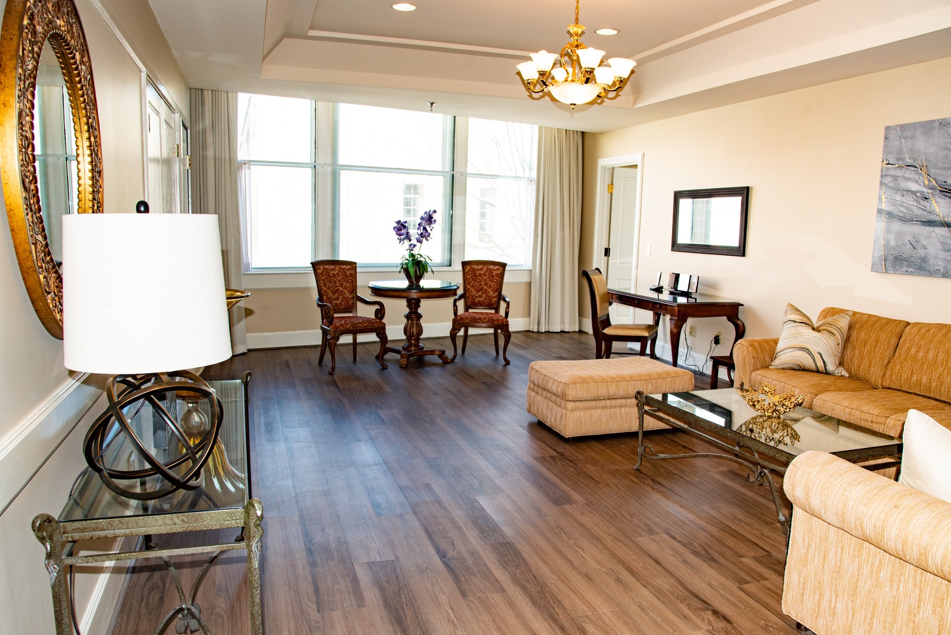 a living room with a wood floor and a chandelier