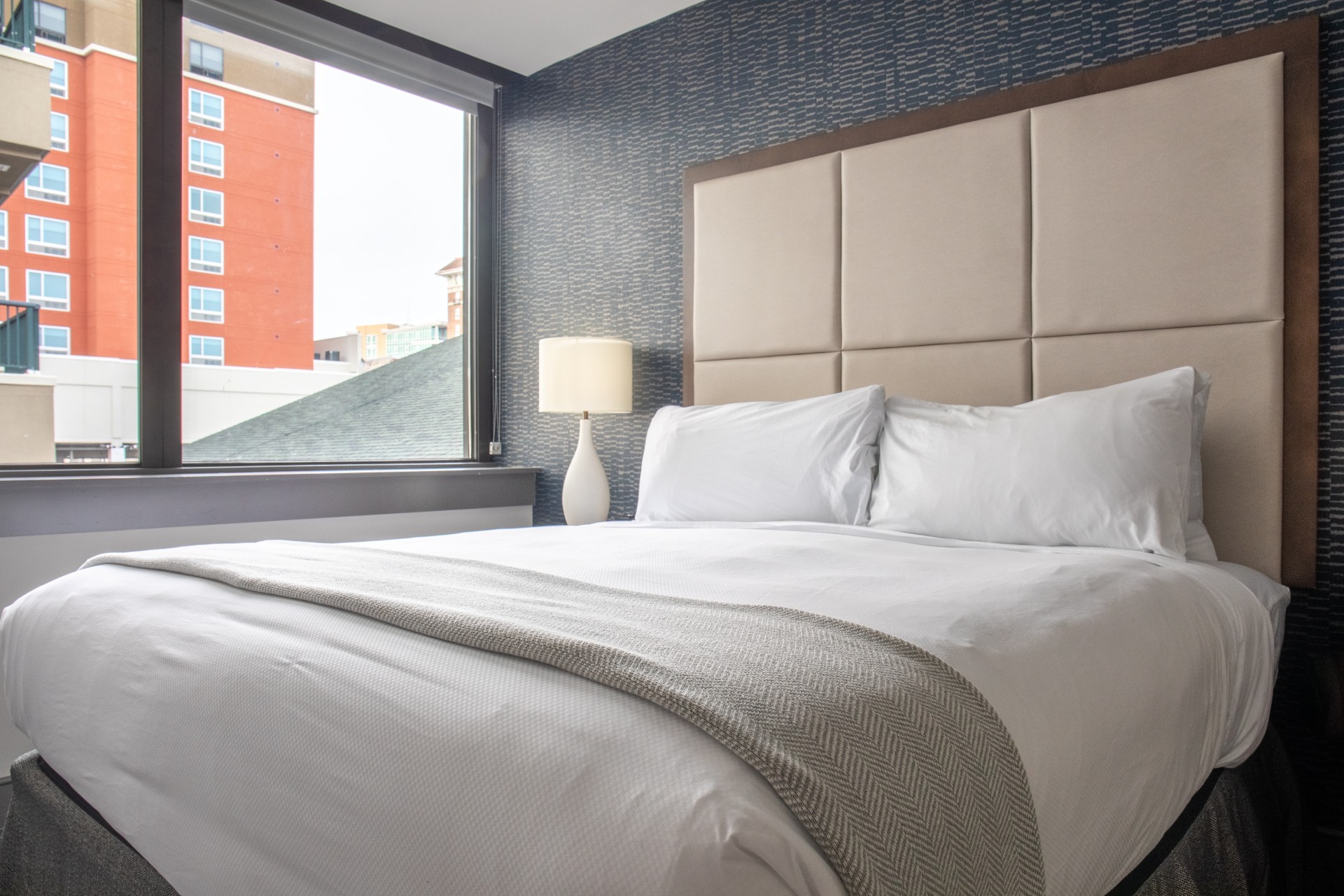 a bed with a lamp next to a window