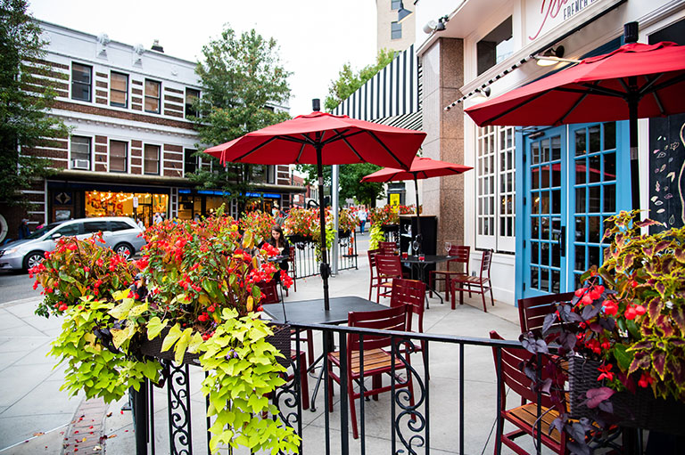 a patio with red umbrellas and flowers