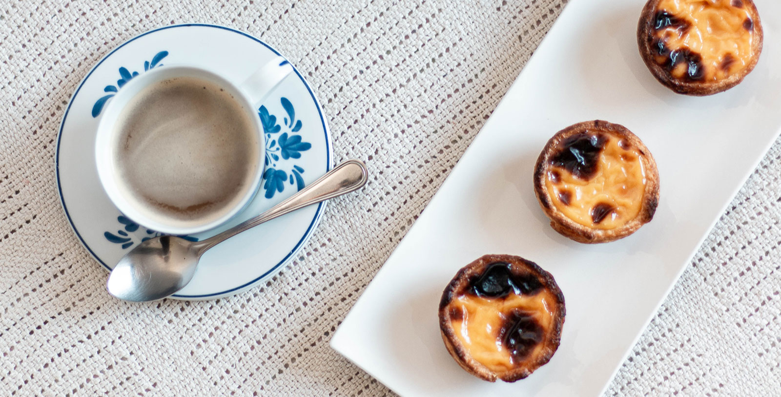 a plate with food on it next to a cup of coffee