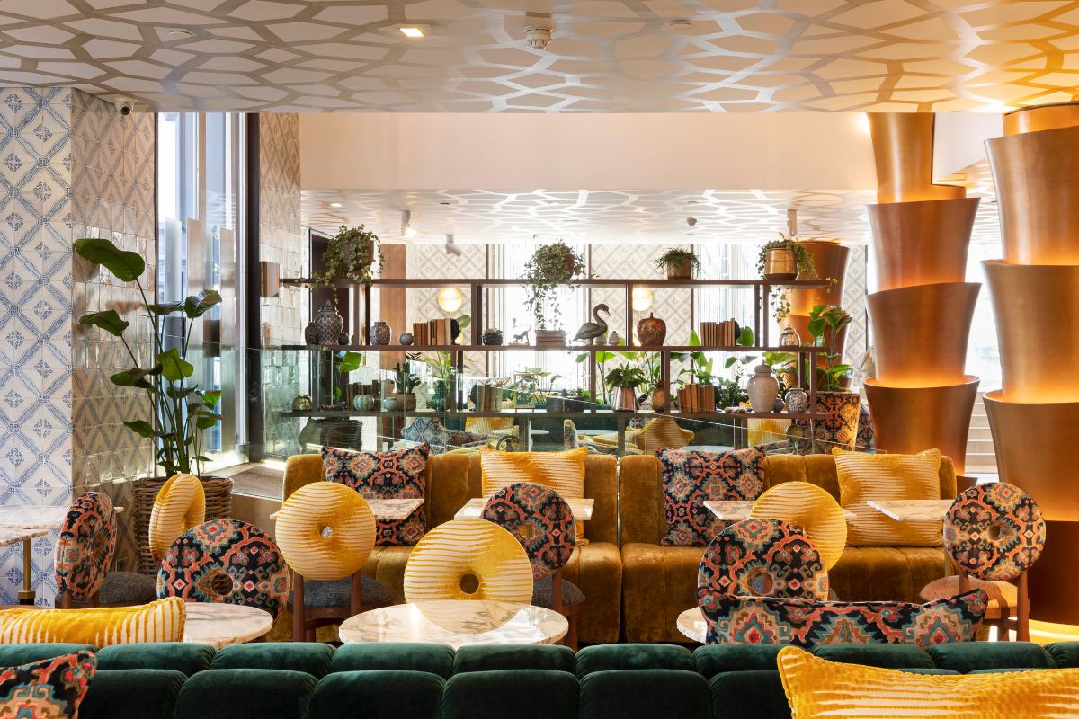 a room with a large window and a large wall with plants and tables