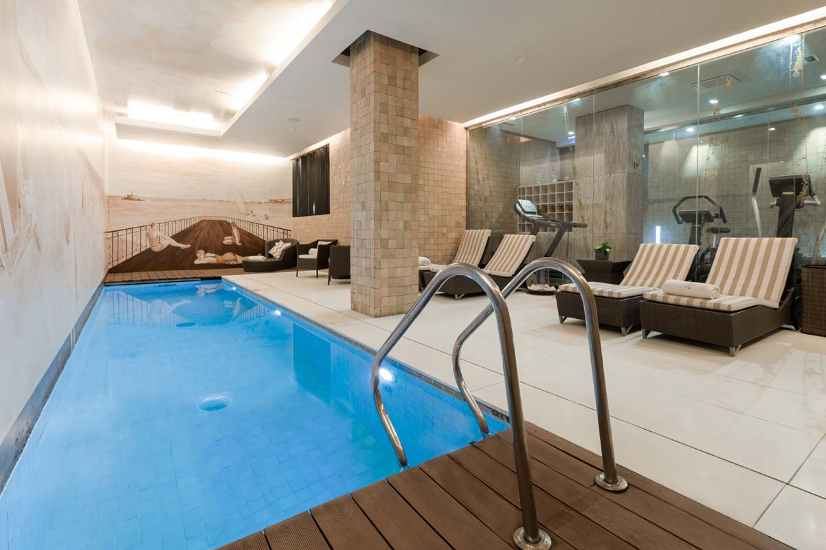 a swimming pool with chairs and a wall painting