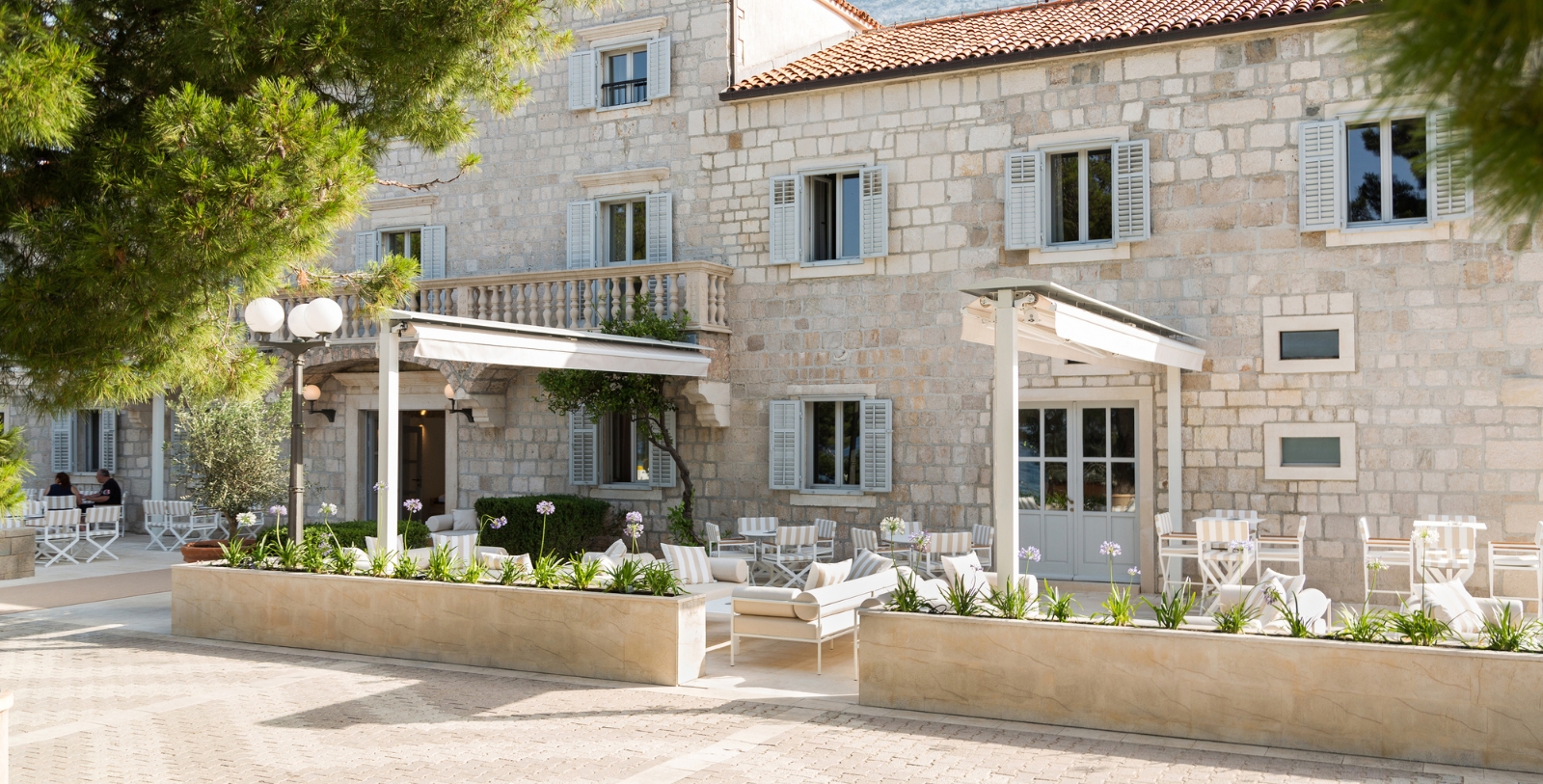 a stone building with a patio area and chairs