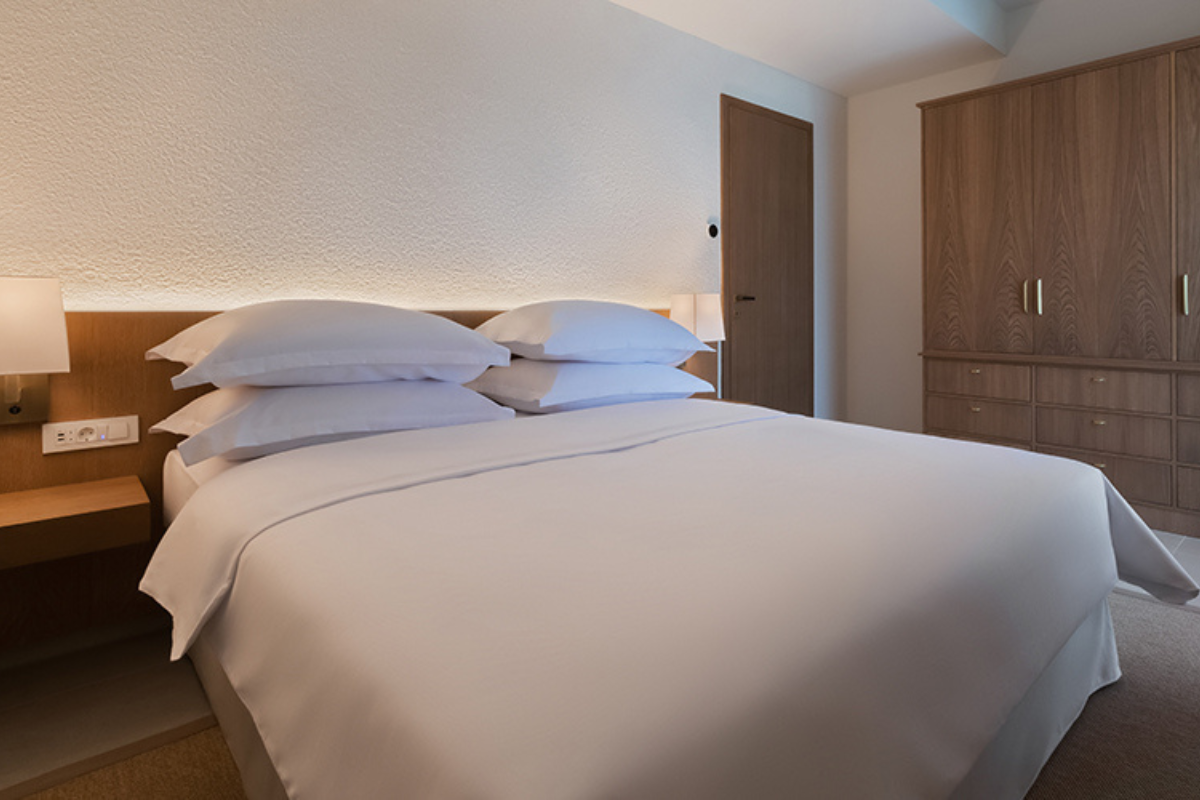 a bed with white sheets and pillows