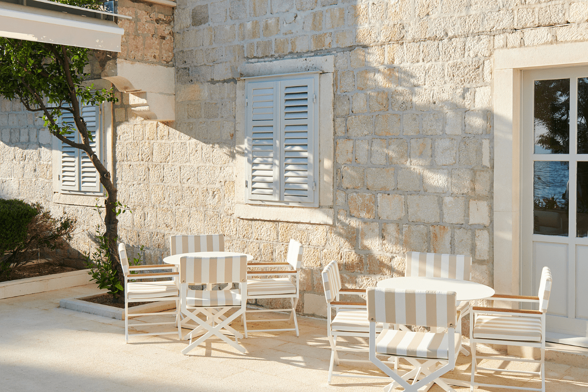 a white chairs and a table outside of a stone building