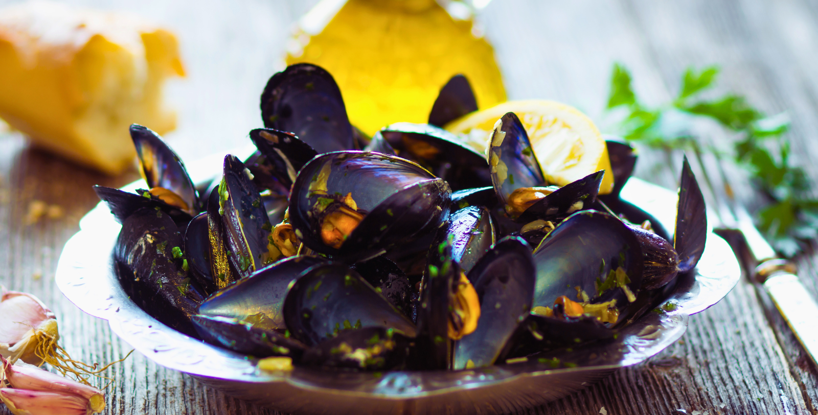 a bowl of mussels with lemon and parsley