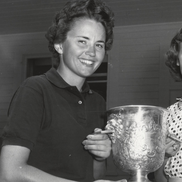 a woman holding a cigarette and a silver trophy