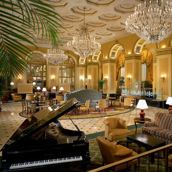 a room with a piano and chandeliers