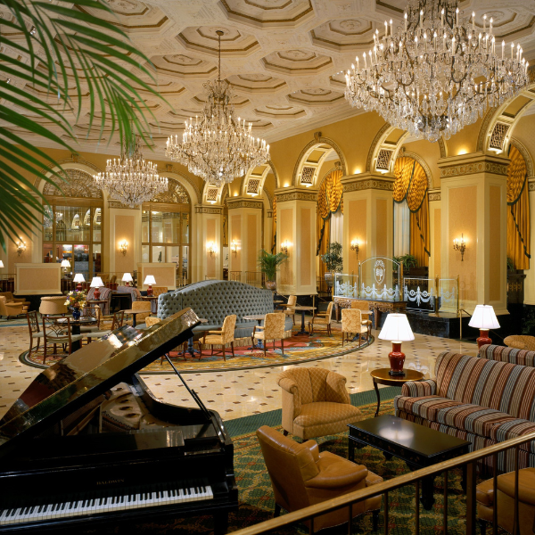 a room with a piano and chandeliers