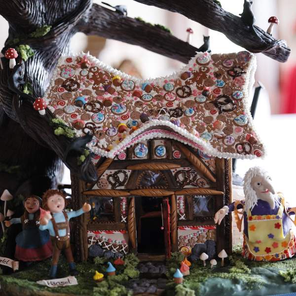 a gingerbread house with a tree and people