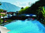 a pool with a house and mountains in the background