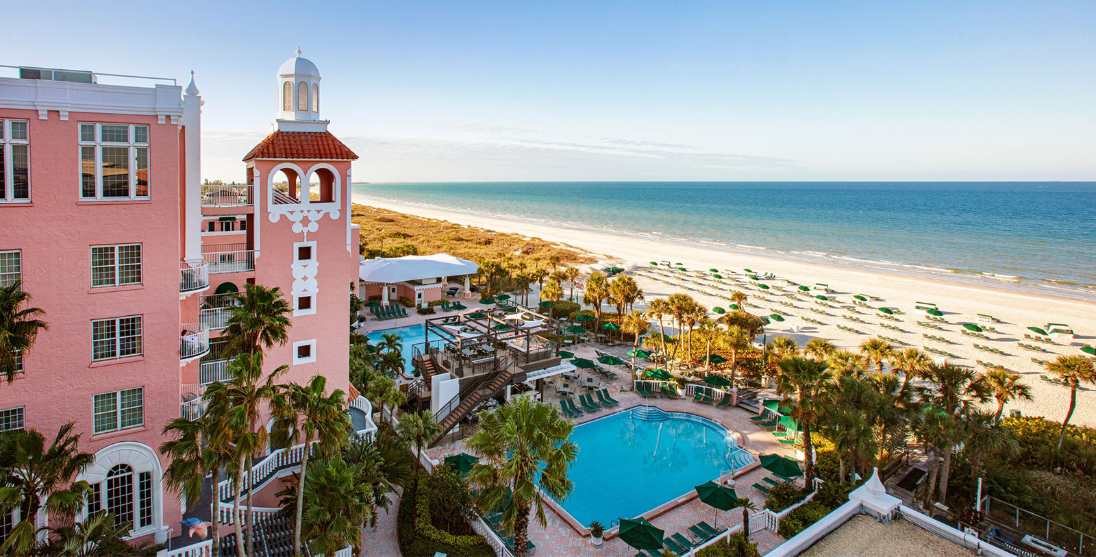 a building with a tower and a pool on a beach