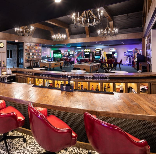 a bar with red chairs and a pool table