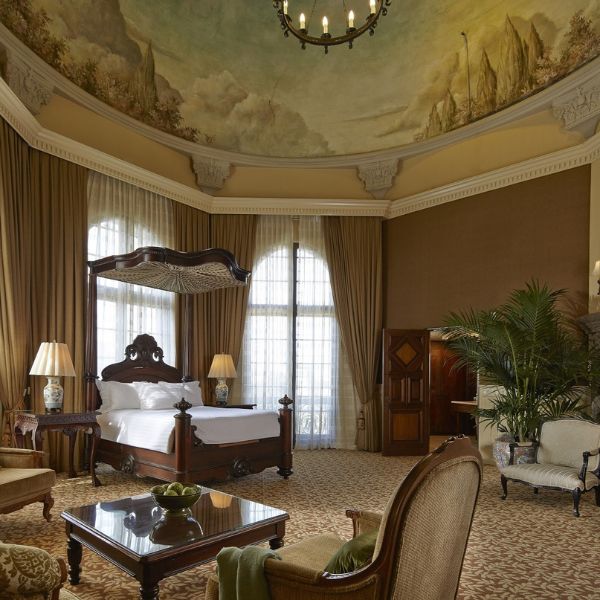 a room with a bed and chairs