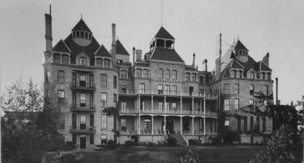 a large building with many windows with New York State Capitol in the background