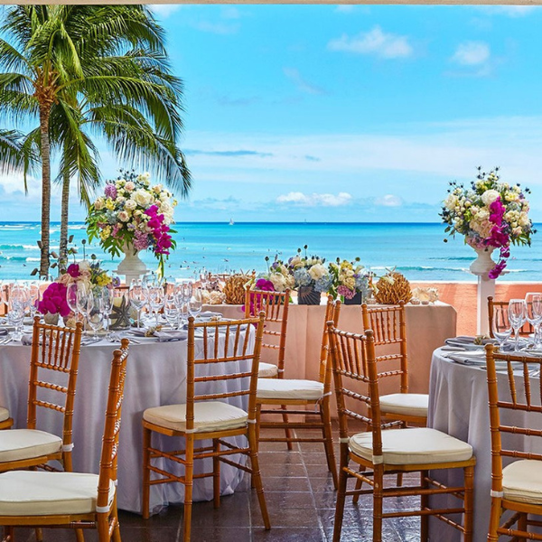 a table set up with chairs and flowers on it
