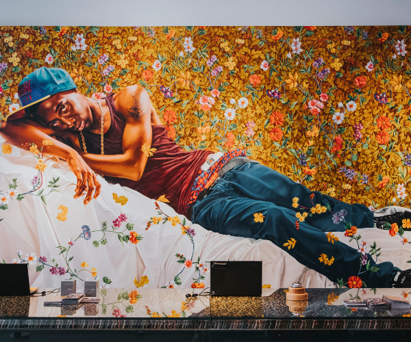 a man lying on a bed with flowers on the wall