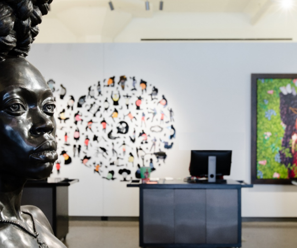 a statue of a woman in a room with a large round wall with many pictures
