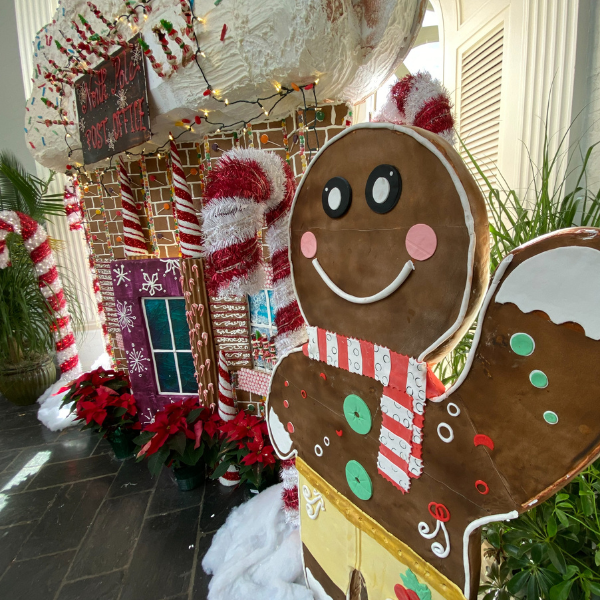 a gingerbread man and candy canes in front of a gingerbread house