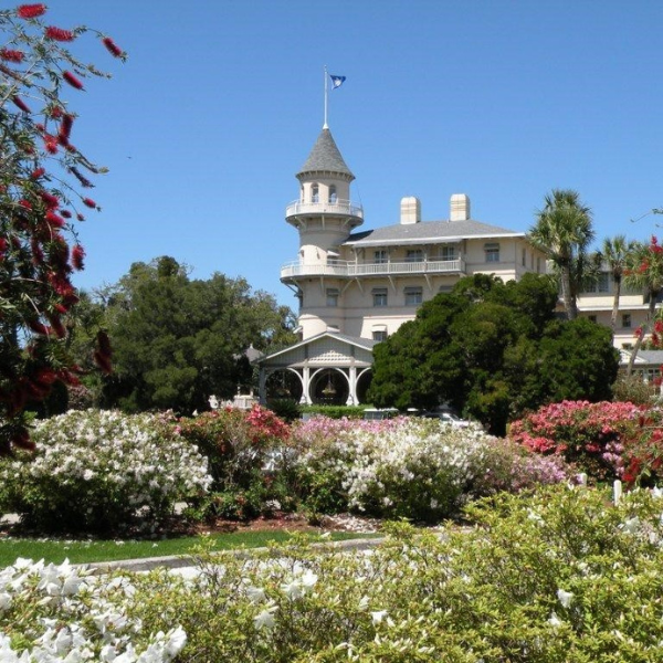 a large white building with a tower and a garden