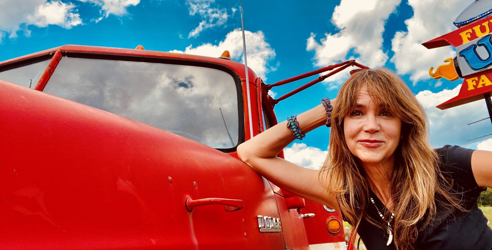 a woman leaning against a red truck