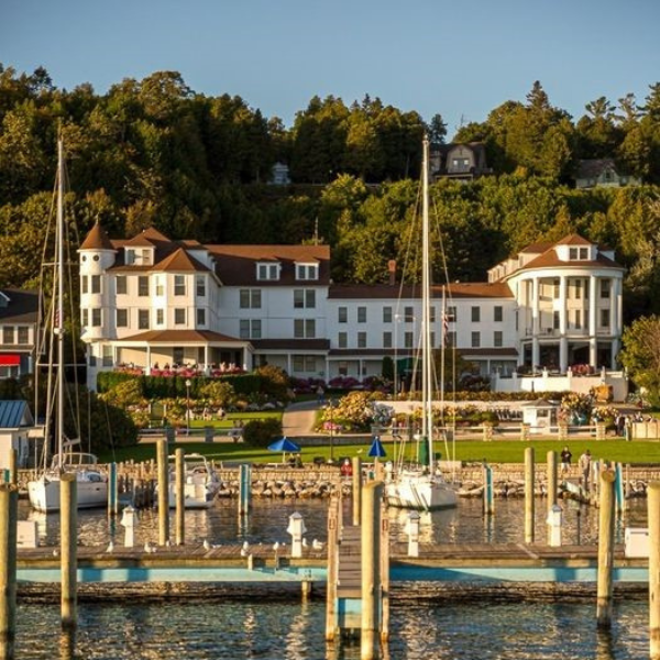 a large white building with many sailboats in front of a body of water