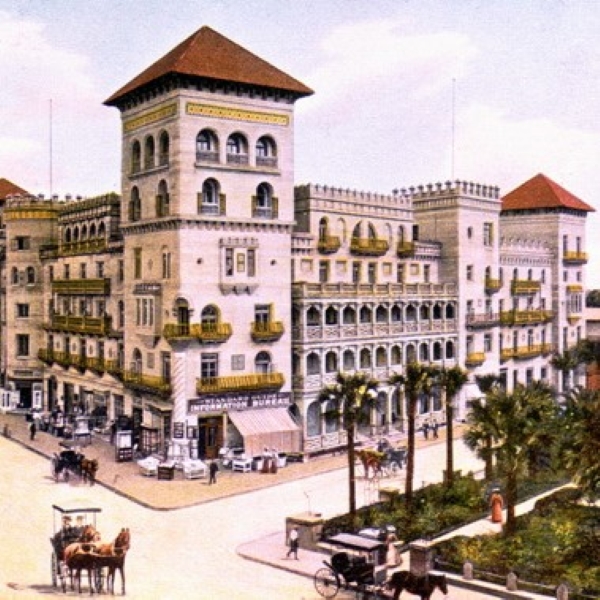 a large building with a horse carriage and palm trees with Beverly Wilshire Hotel in the background