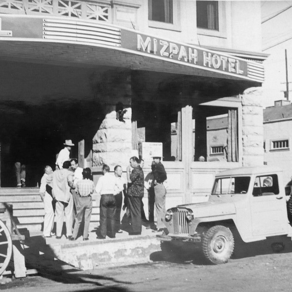 a group of people standing outside a hotel