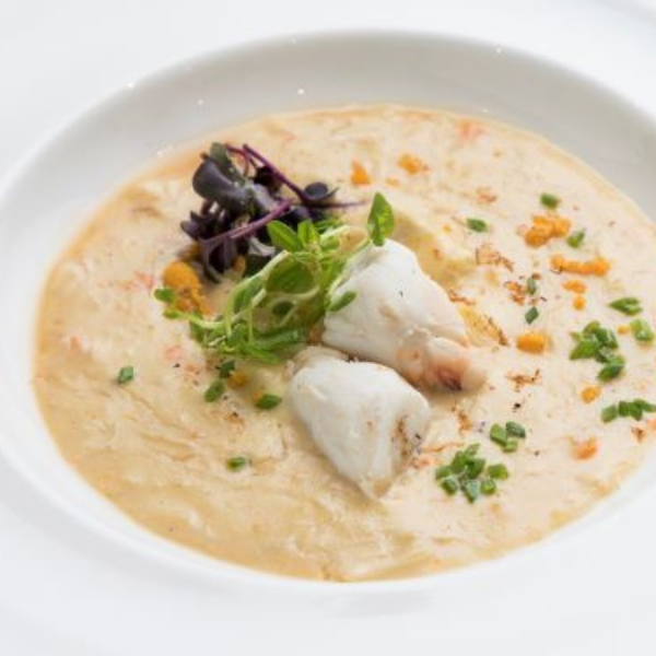 a bowl of soup with vegetables and herbs