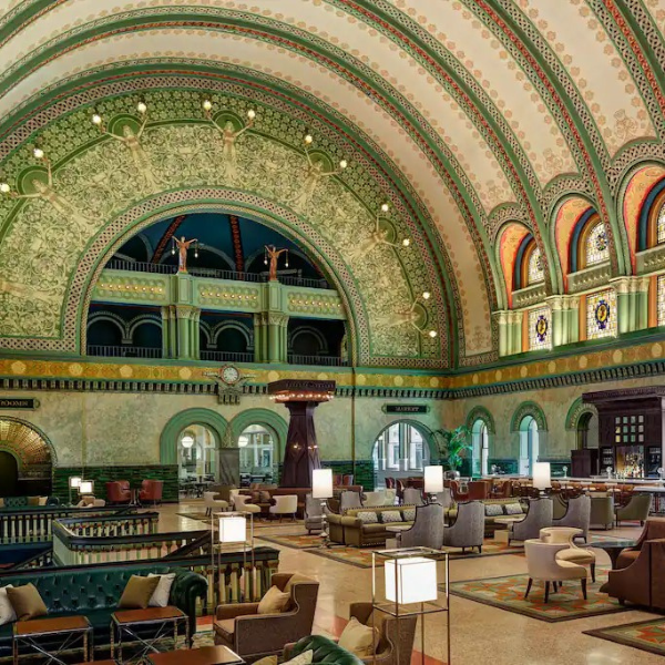 a large ornate building with many chairs and tables with Union Station in the background