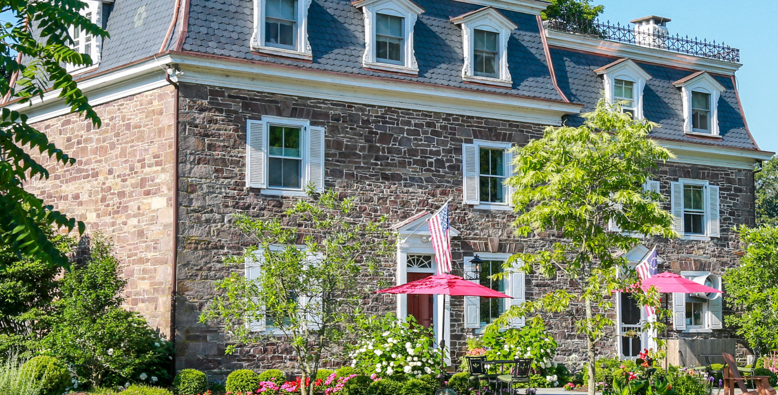 a stone building with a red umbrella and a flag