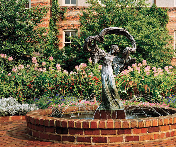 a statue of a woman in a garden
