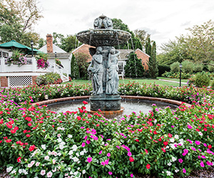 a fountain with a group of statues in a garden