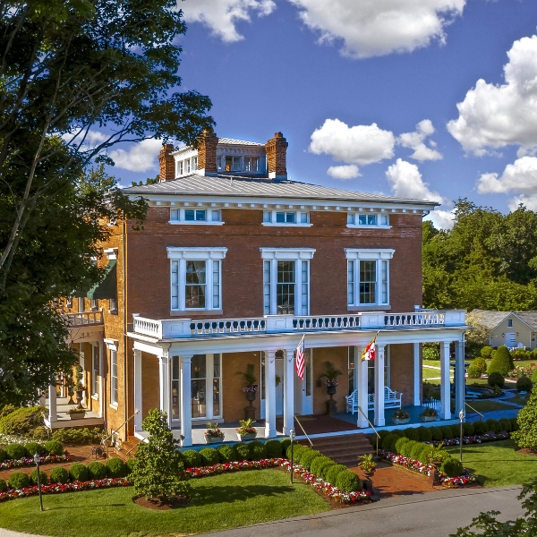 a large brick house with a large porch and a large lawn