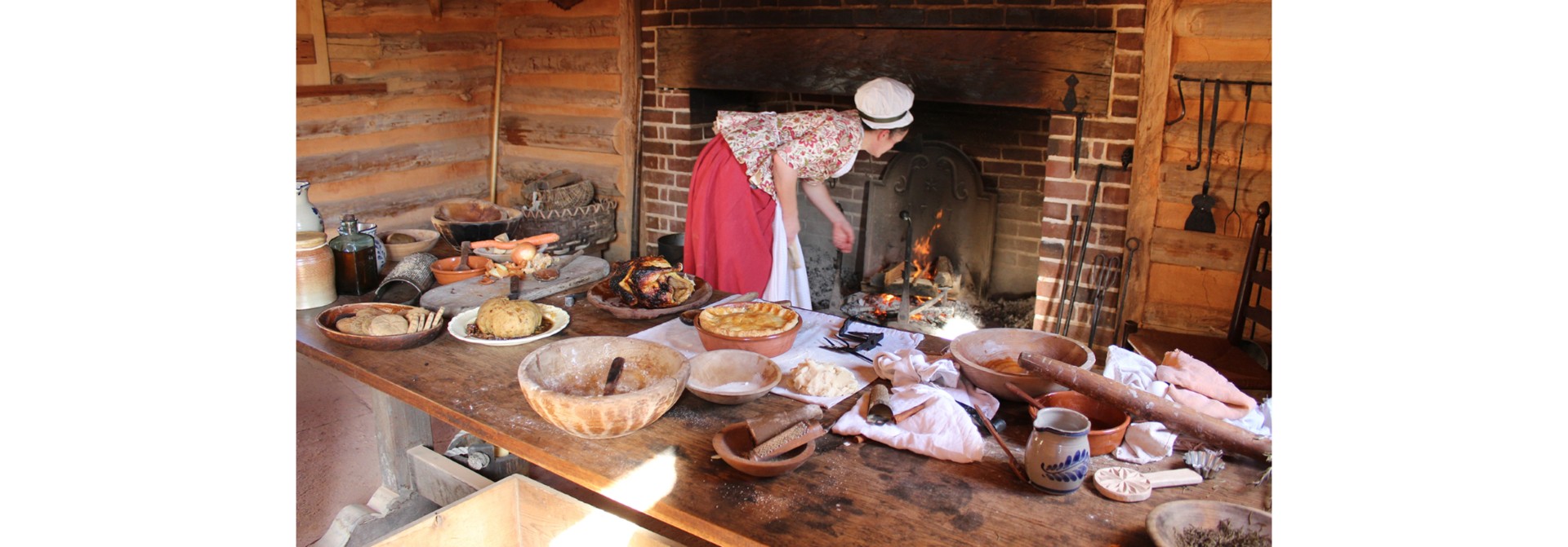 a woman in a red dress standing in front of a fireplace