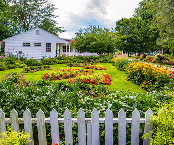 a white house with a garden and a white picket fence