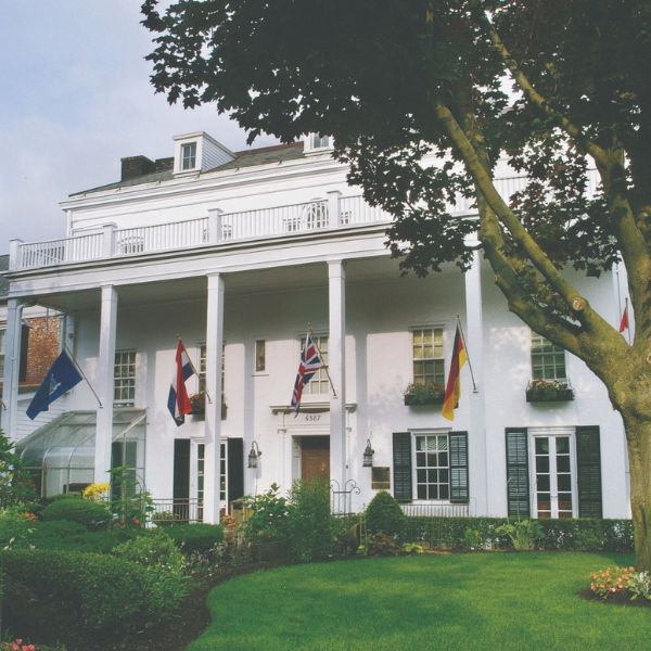 a white house with flags on the front with Washington Place in the background