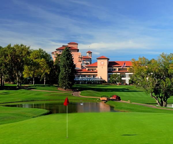 a golf course with a large building in the background